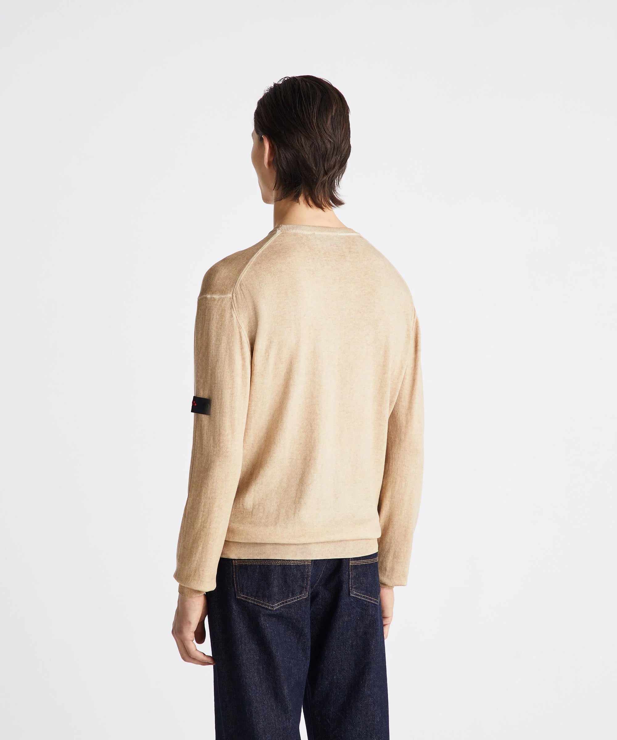 Maglione beige uomo, visto da dietro, abbinato a jeans scuri, stile casual elegante.