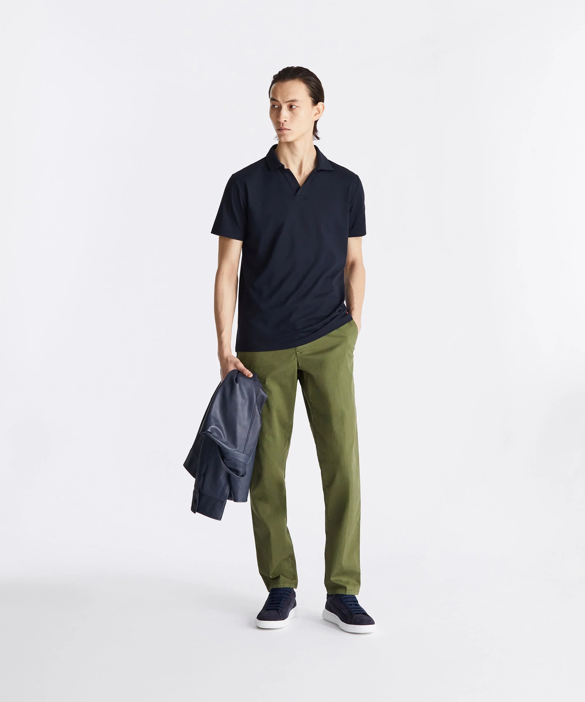 Modello uomo con polo blu, pantaloni verdi e sneakers blu, stile casual elegante