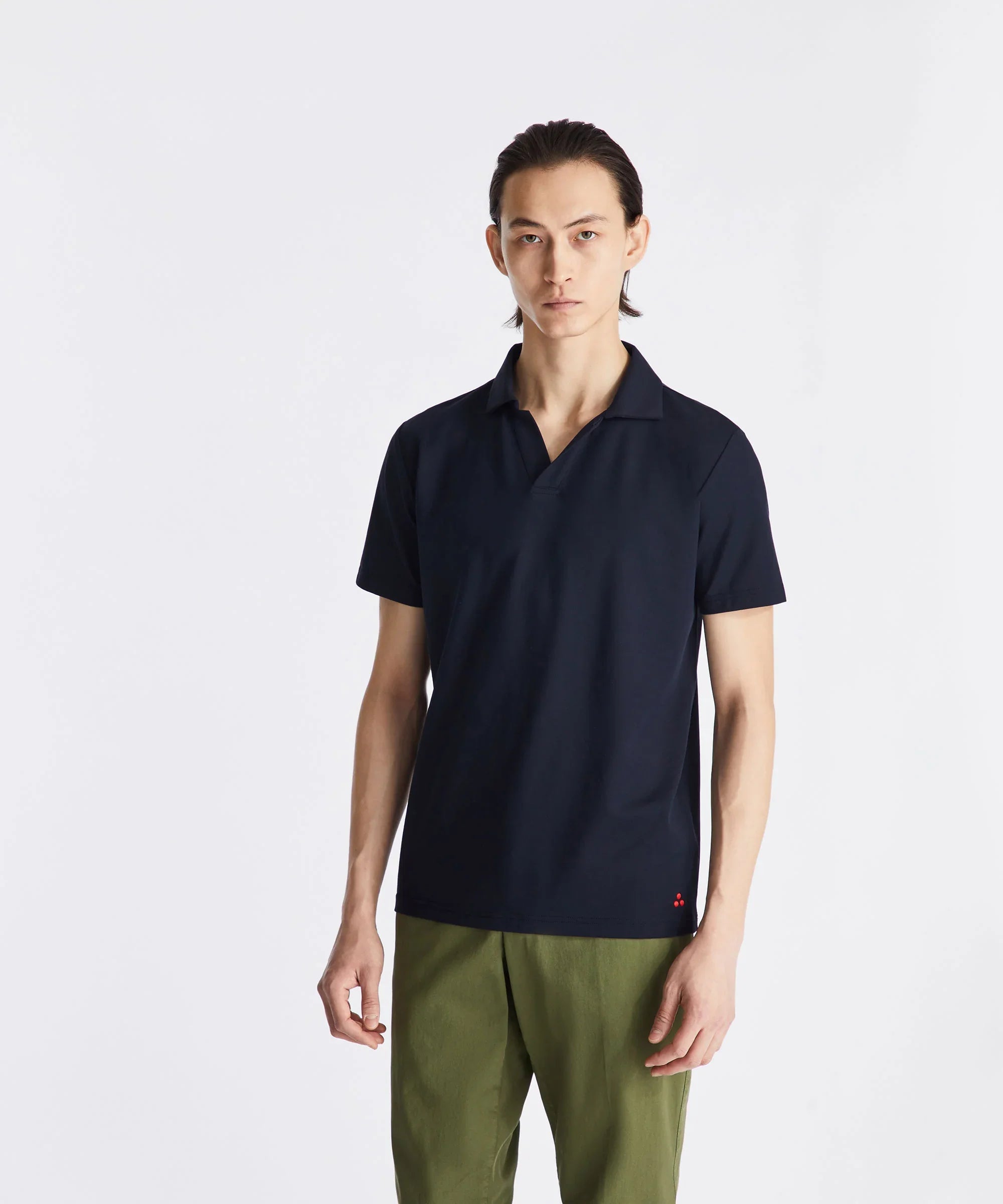 Modello uomo con polo blu scuro a manica corta e pantaloni verdi, stile casual elegante
