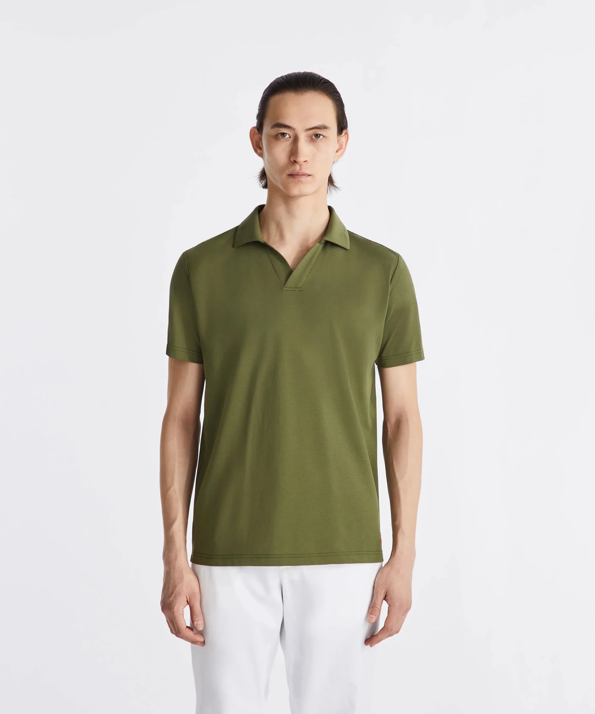Uomo con polo verde in cotone e pantaloni bianchi, moda uomo casual elegante