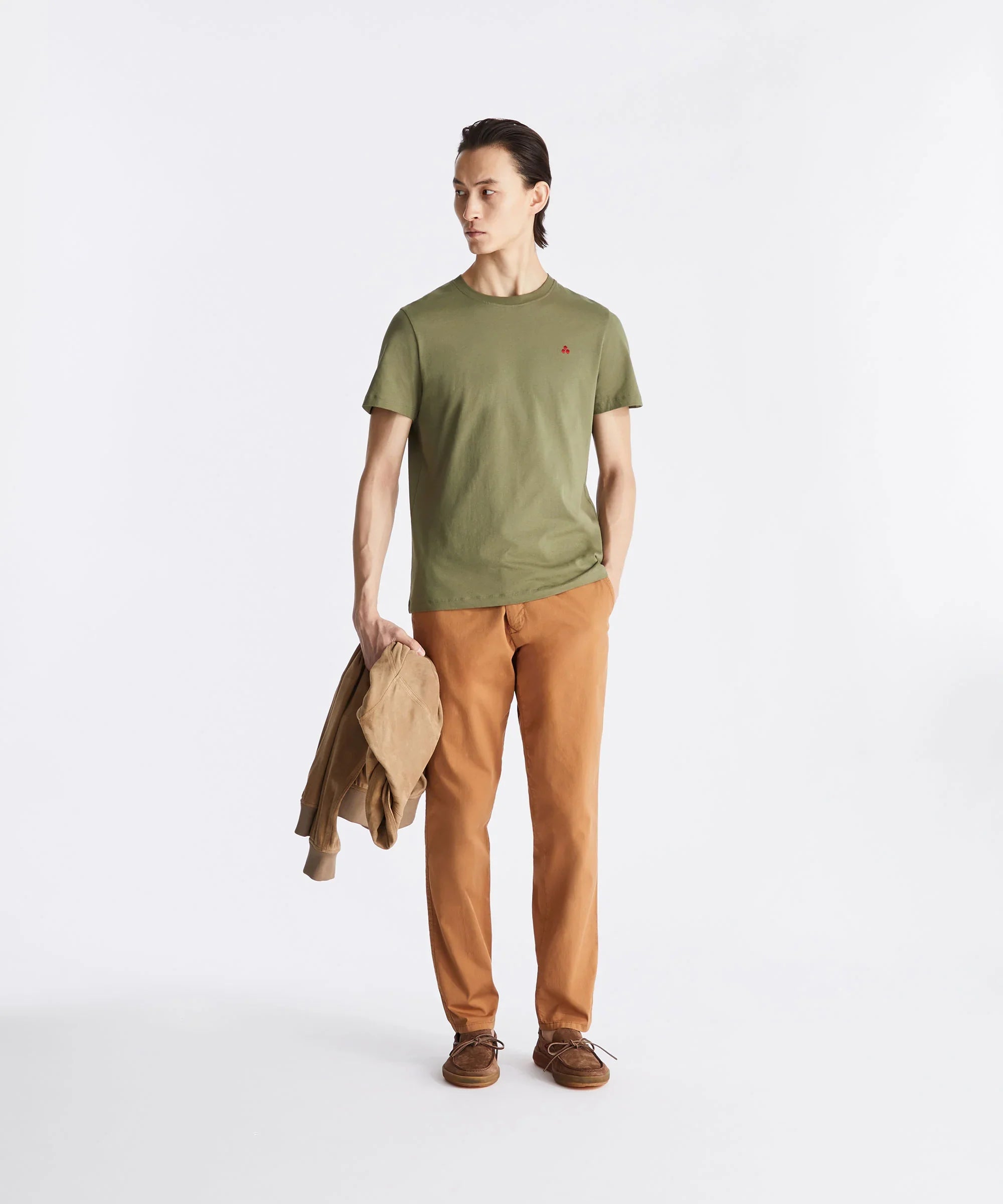 Modello indossa t-shirt verde oliva e pantaloni arancioni, look casual uomo moderno