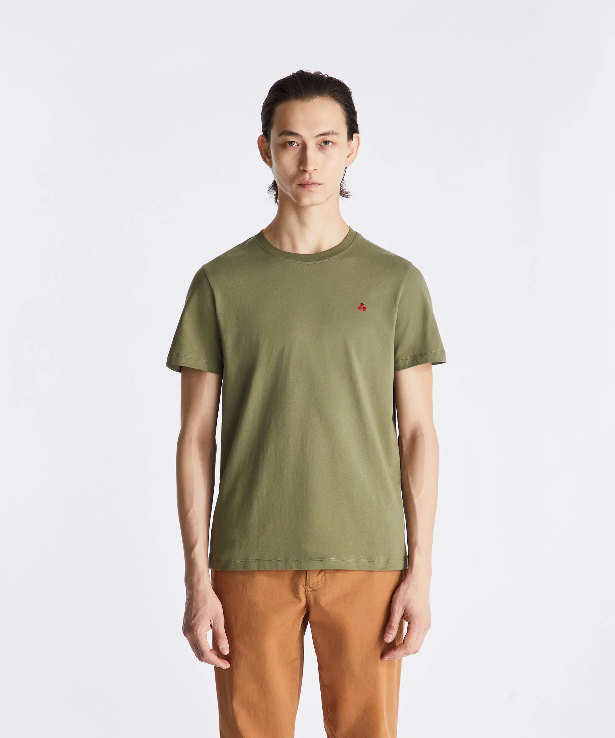 Modello indossa t-shirt verde militare da uomo con logo rosso e pantaloni color cuoio