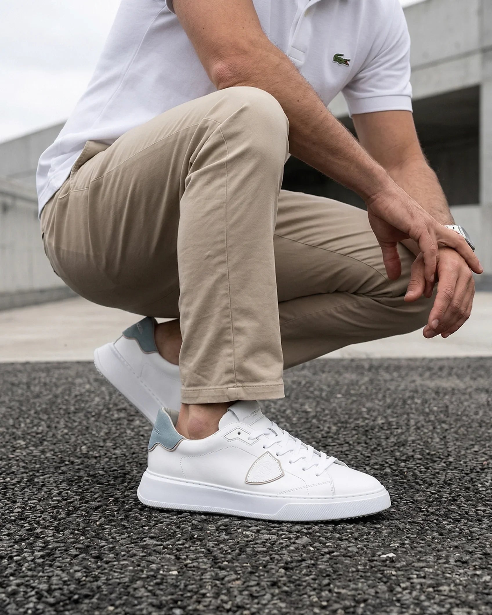 Sneaker bianca uomo Philippe Model, dettaglio design moderno su sfondo urbano