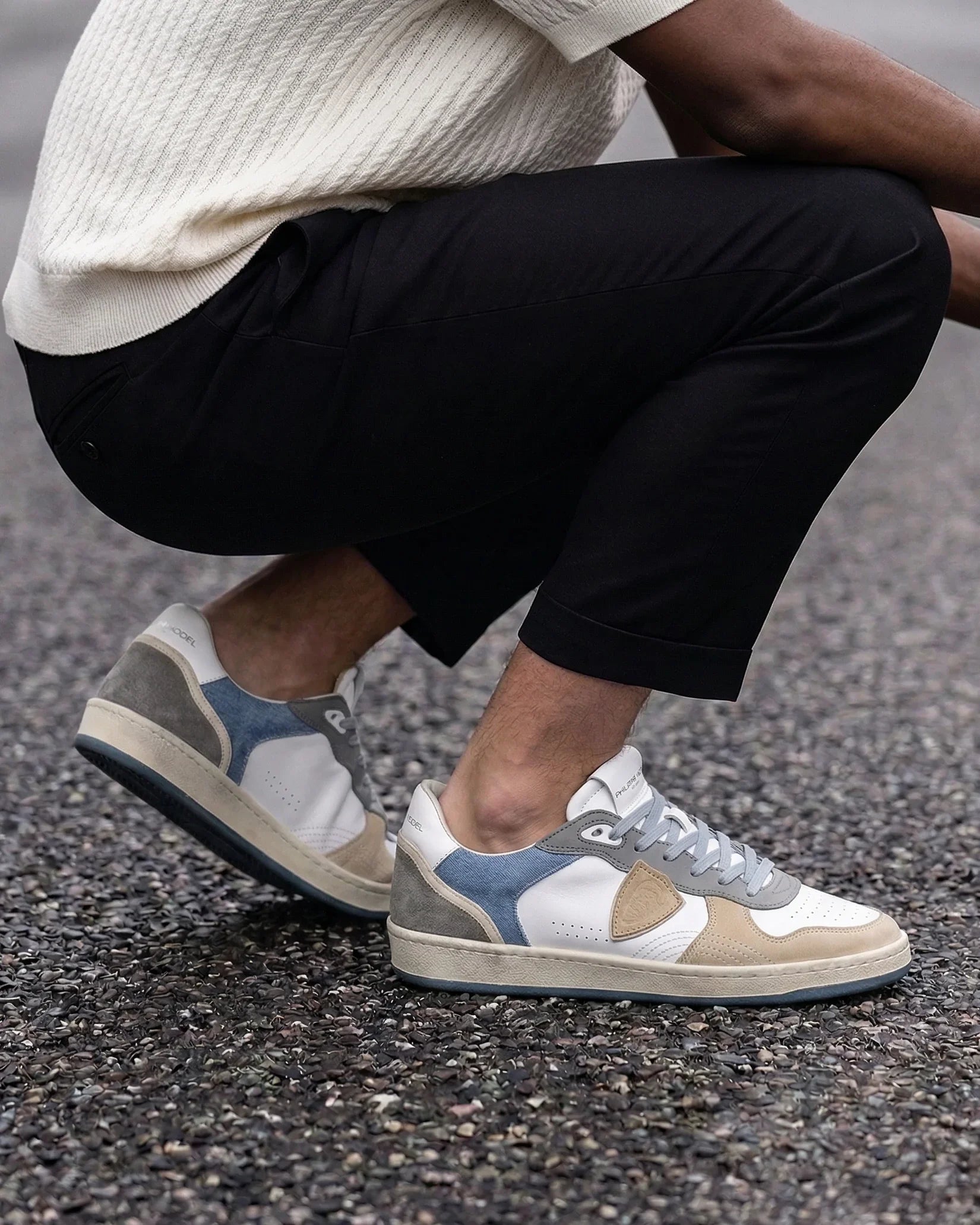 Sneakers uomo in pelle e suede beige, grigio e bianco, moda casual su fondo stradale