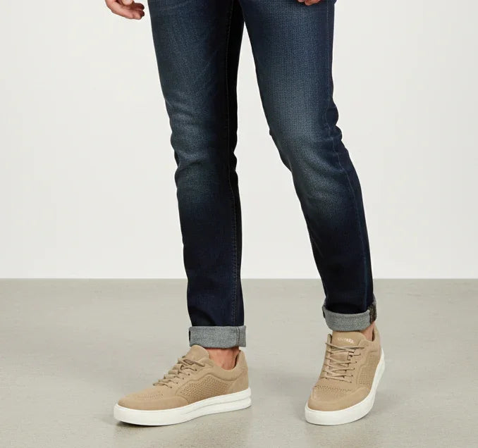 Jeans uomo slim fit blu scuro con risvolto e sneakers beige, abbigliamento casual elegante