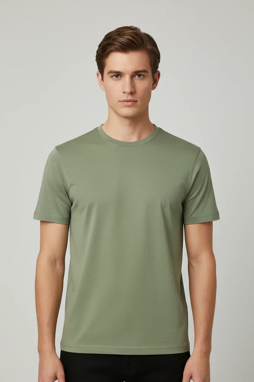 Modello uomo indossa t-shirt verde militare a maniche corte, stile casual, su sfondo neutro.