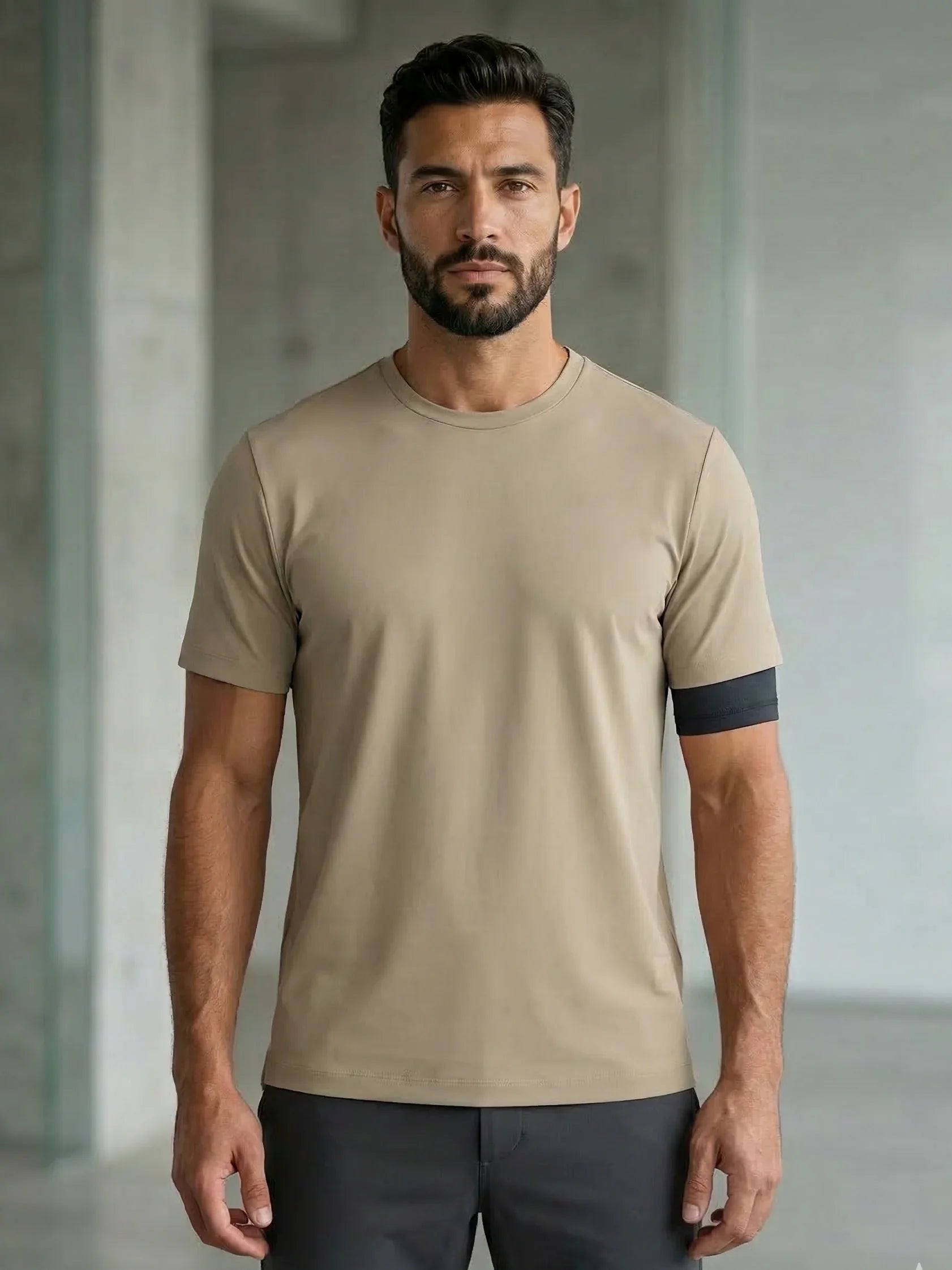 Modello uomo indossa t-shirt beige minimalista, moda uomo casual, ambiente moderno.