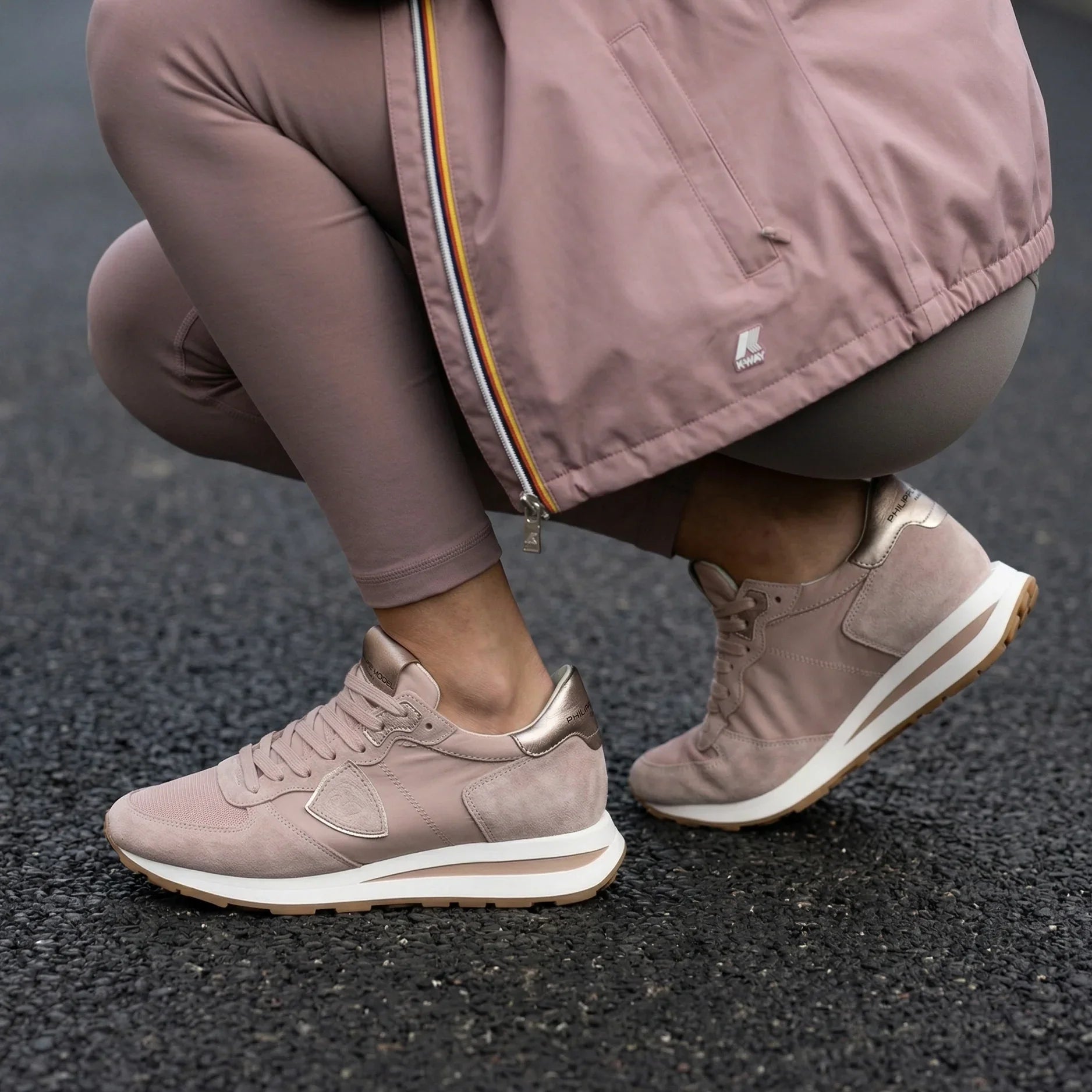 Sneakers rosa donna con dettagli metallici oro, abbinate a leggings sportivi, su asfalto