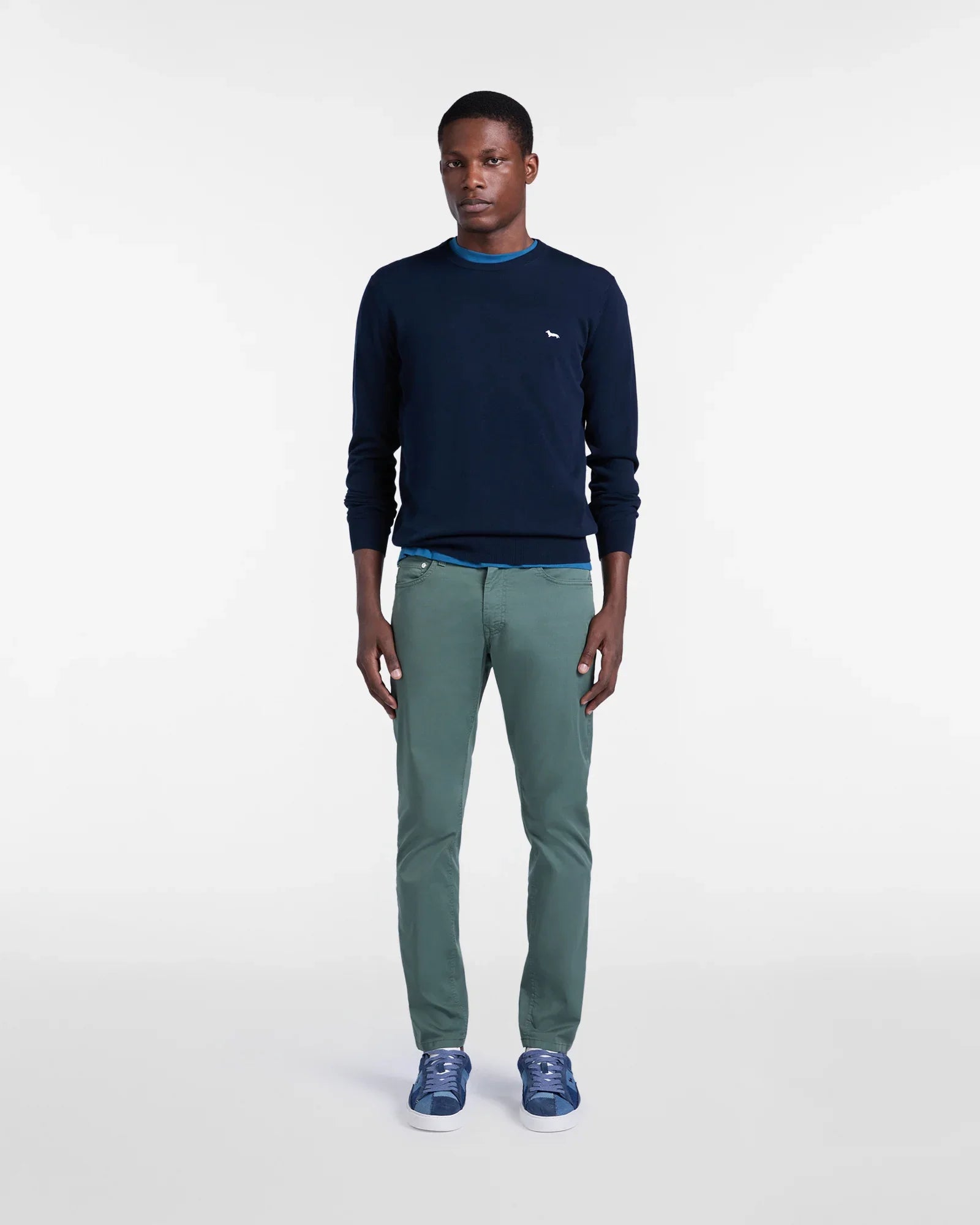 Modello con maglione blu, pantaloni verde chiaro e sneakers blu, stile casual uomo