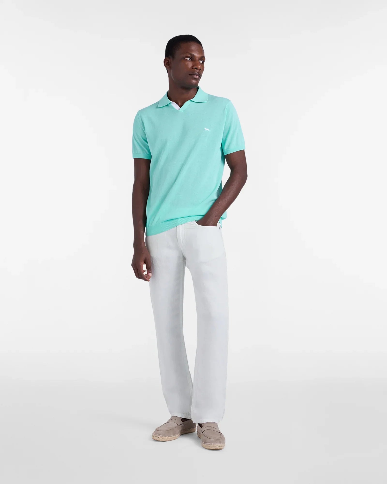 Uomo con polo verde acqua, pantaloni bianchi e mocassini beige, moda estiva elegante