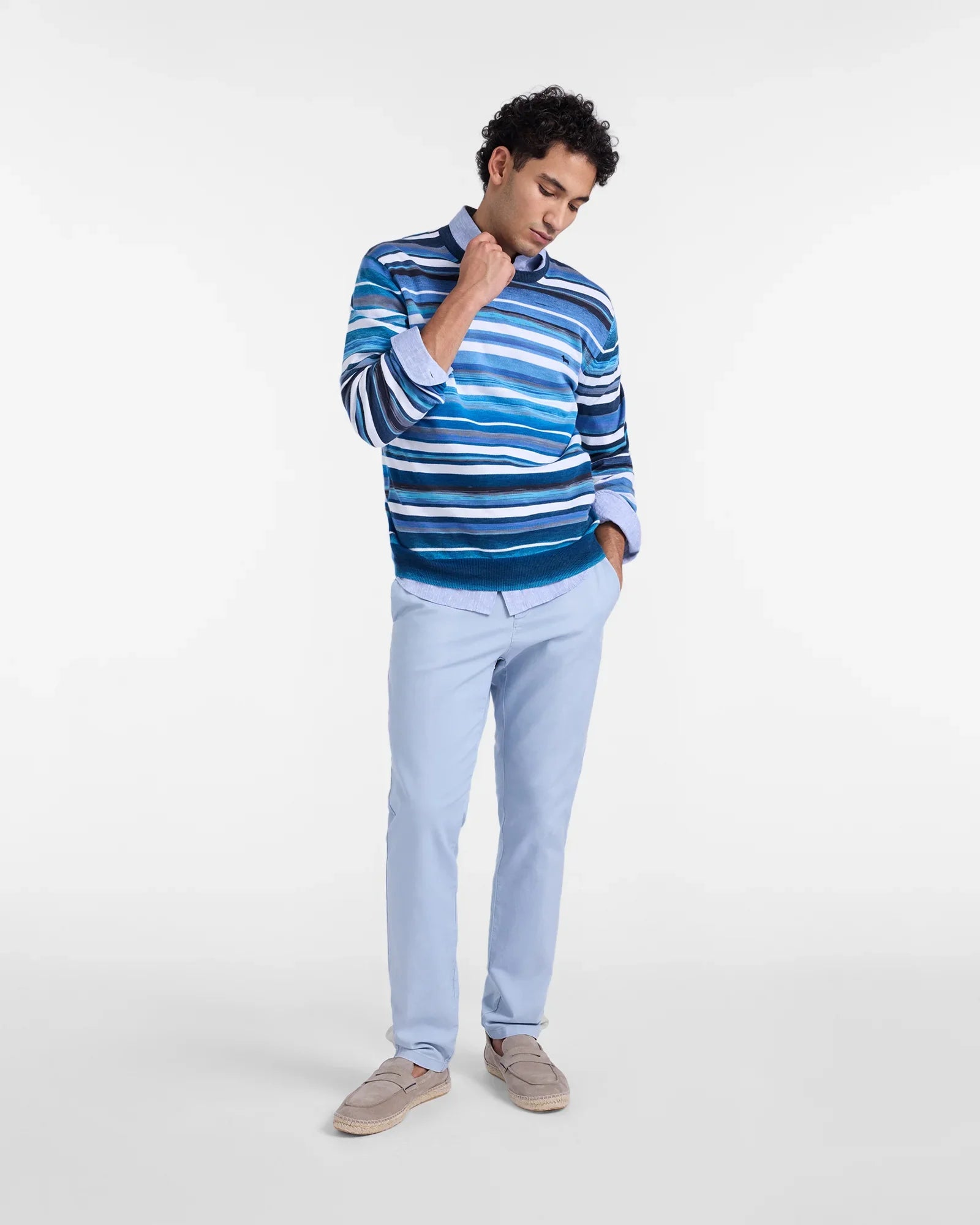 Modello uomo indossa maglione a righe blu e pantaloni celesti, look moda uomo primavera estate.