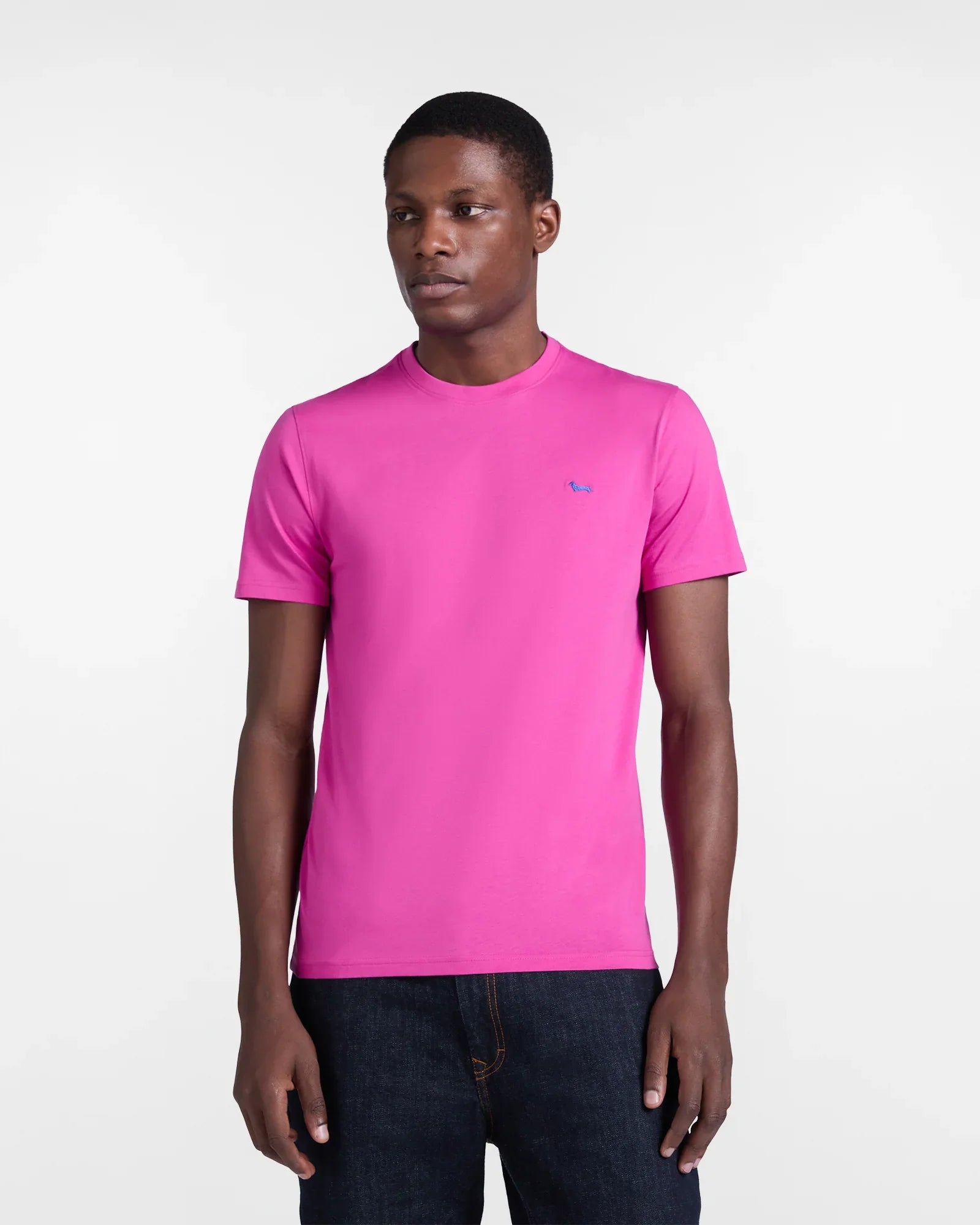 Modello indossa t-shirt uomo fucsia a maniche corte con logo ricamato sul petto, stile casual.