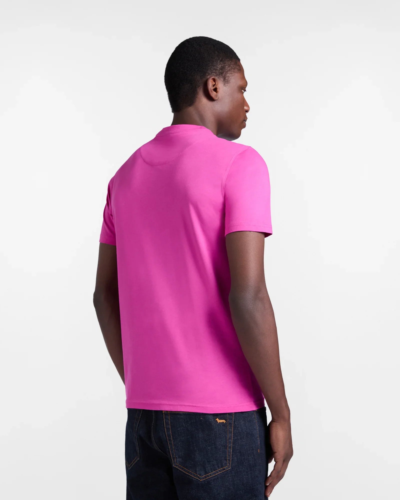 Maglietta uomo rosa a maniche corte abbinata a jeans scuri, vista posteriore, moda casual.