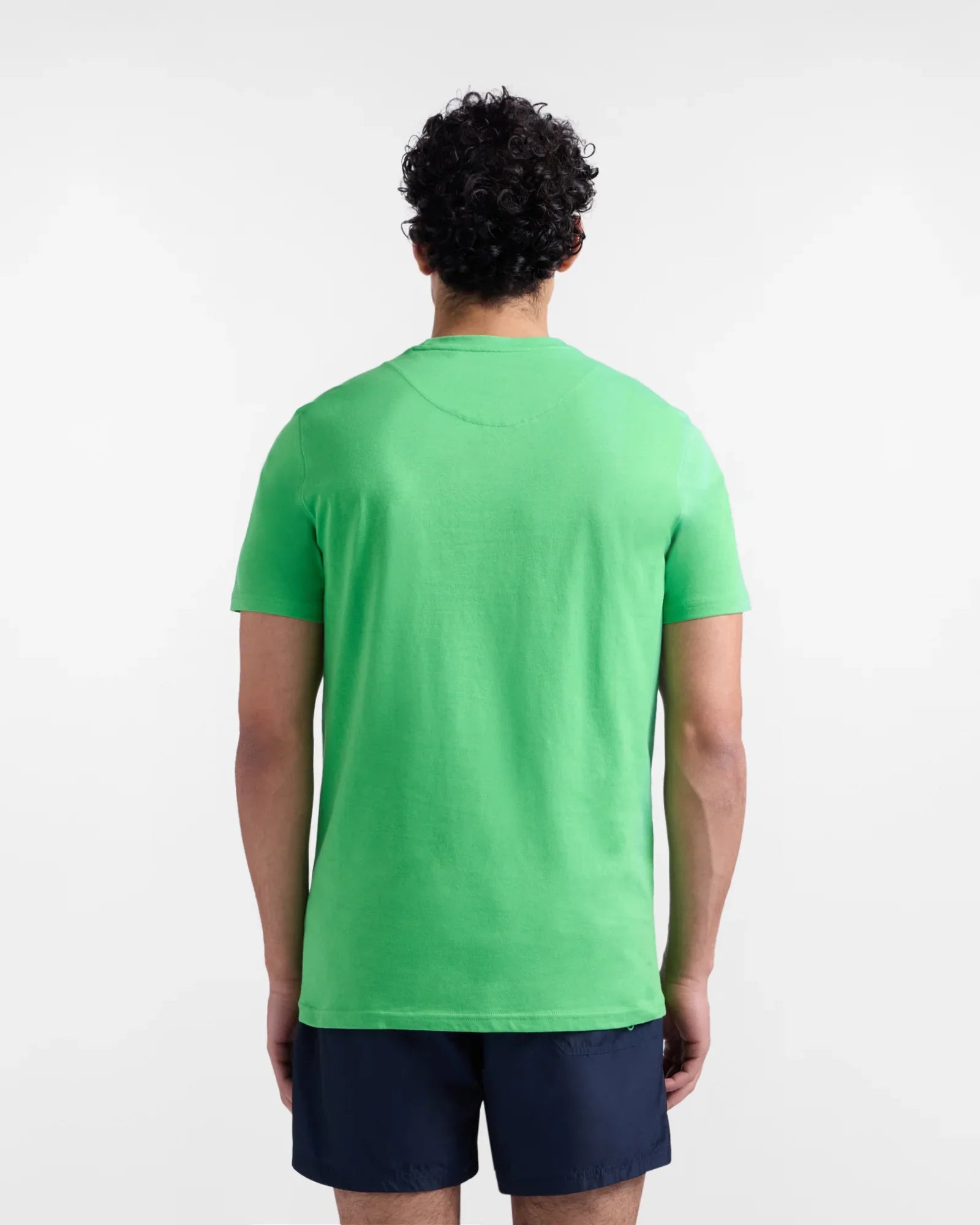 Maglietta verde uomo vista posteriore, pantaloncini blu, abbigliamento casual estivo
