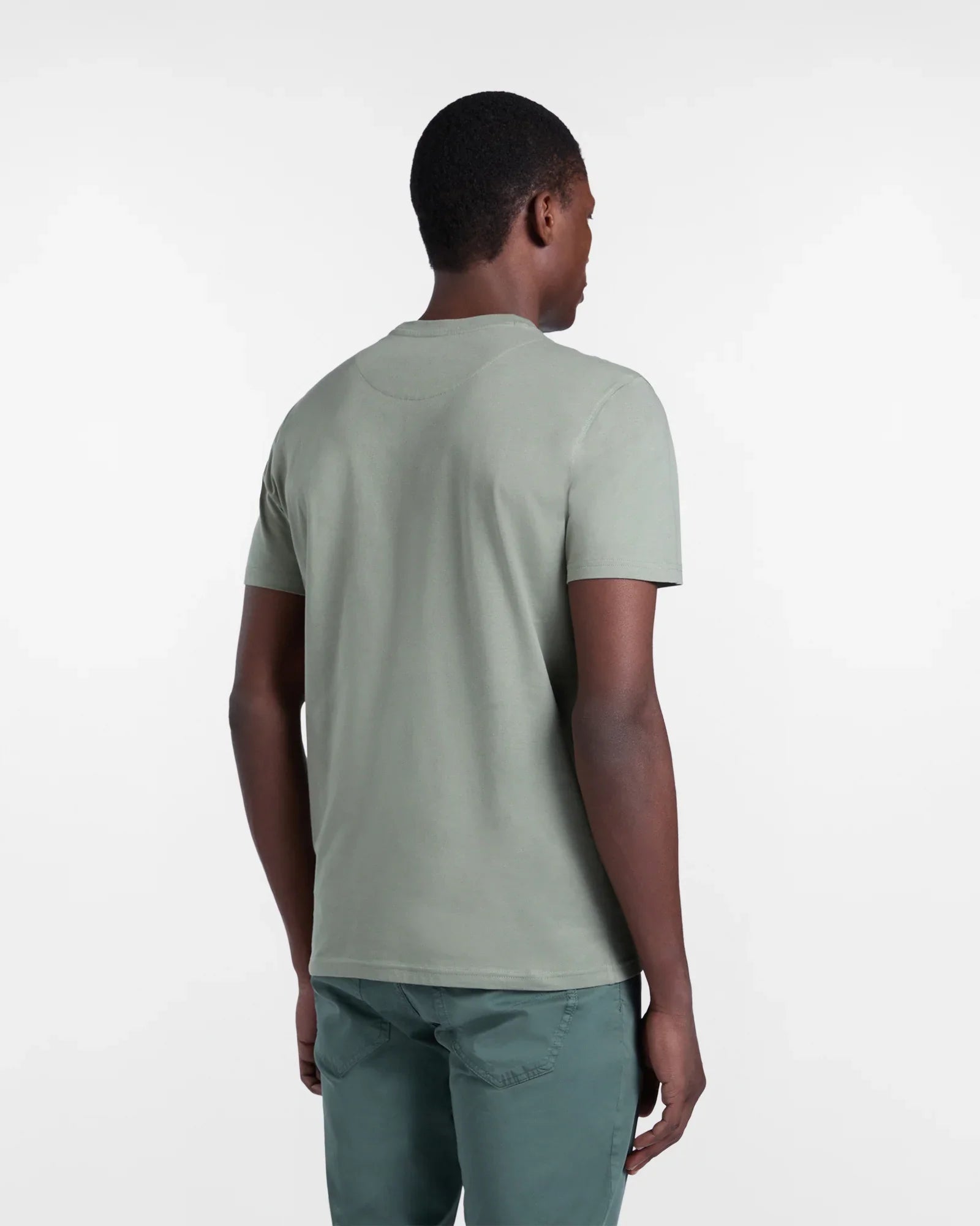 Uomo di spalle con t-shirt e pantaloni verde salvia, abbigliamento casual uomo