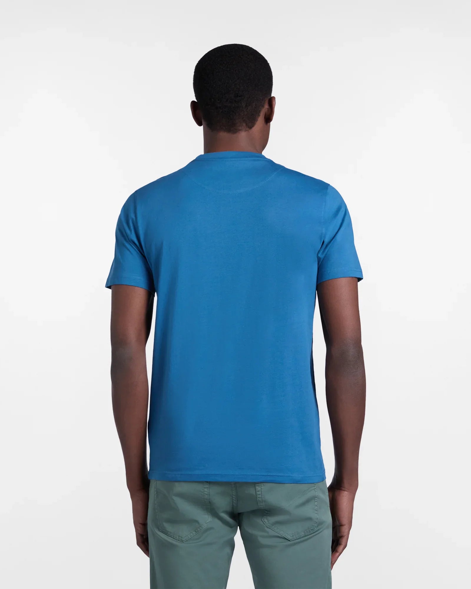 Uomo di spalle con t-shirt blu e pantaloni verdi, moda casual uomo