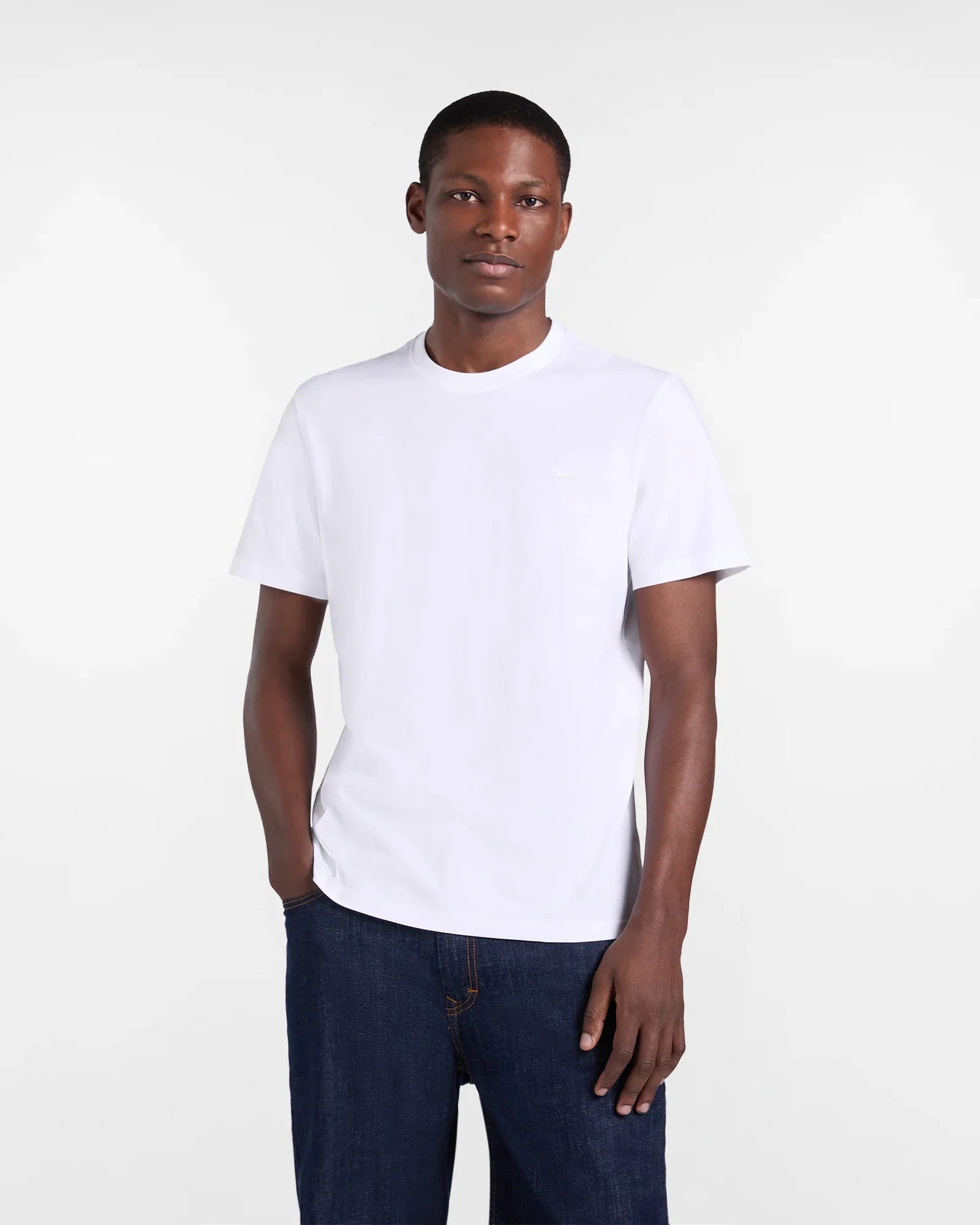 Uomo indossa t-shirt bianca basic a maniche corte e jeans blu, moda casual uomo