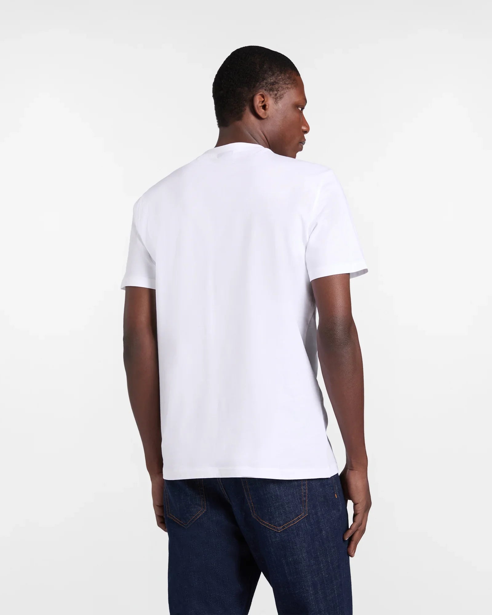 uomo con t-shirt bianca basic a maniche corte e jeans blu, vista posteriore