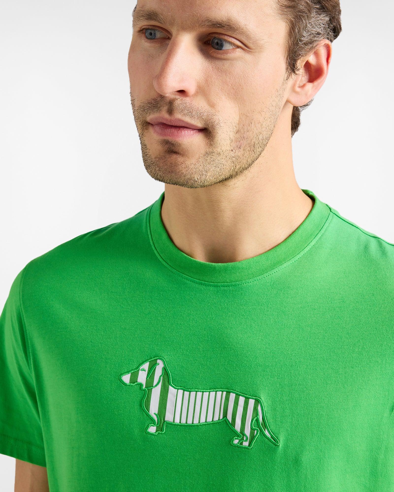 Uomo con t-shirt verde decorata con bassotto a righe, moda uomo casual.