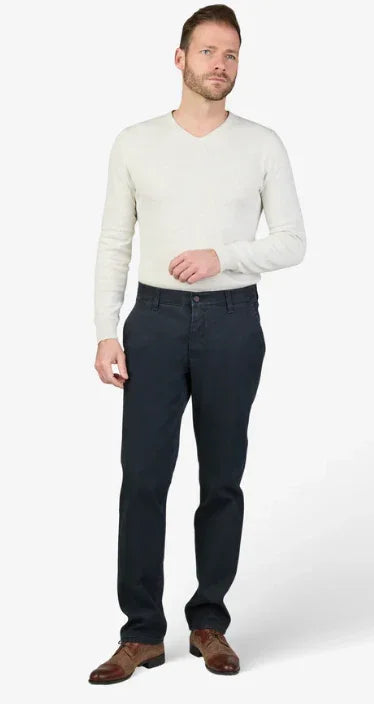 Uomo con maglione chiaro e pantaloni blu scuro, outfit casual elegante uomo