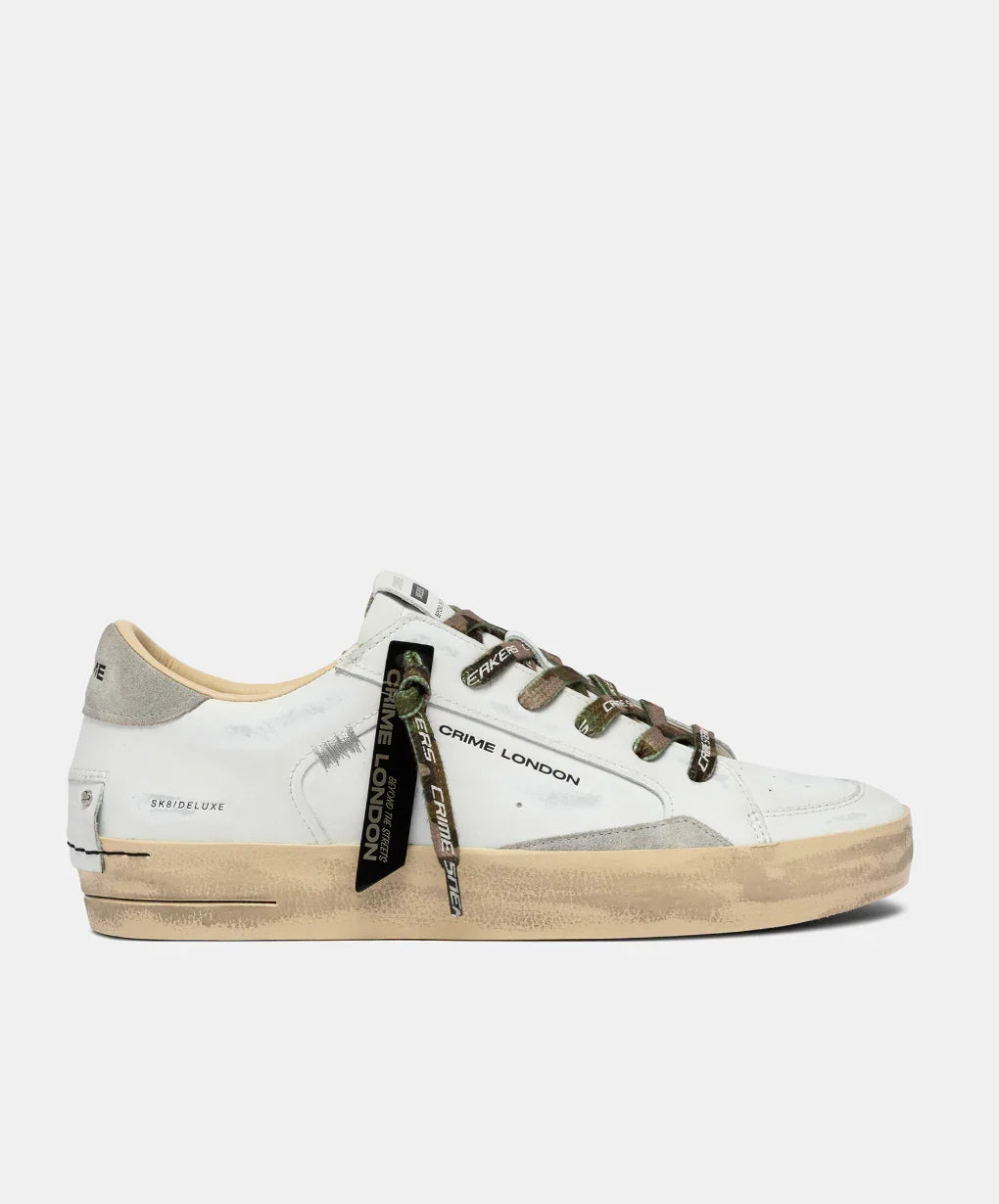 Sneaker uomo bianca con suola beige effetto vintage, dettagli verde, scritta Crime London
