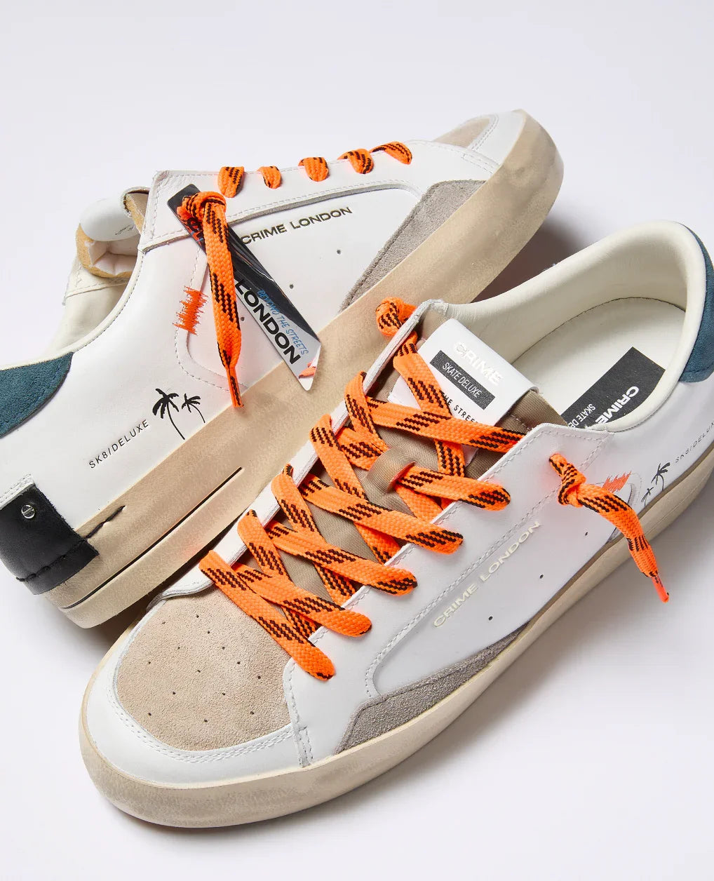 Sneakers basse Crime London uomo, pelle bianca e beige, dettagli arancioni e palme stampate, stile casual.