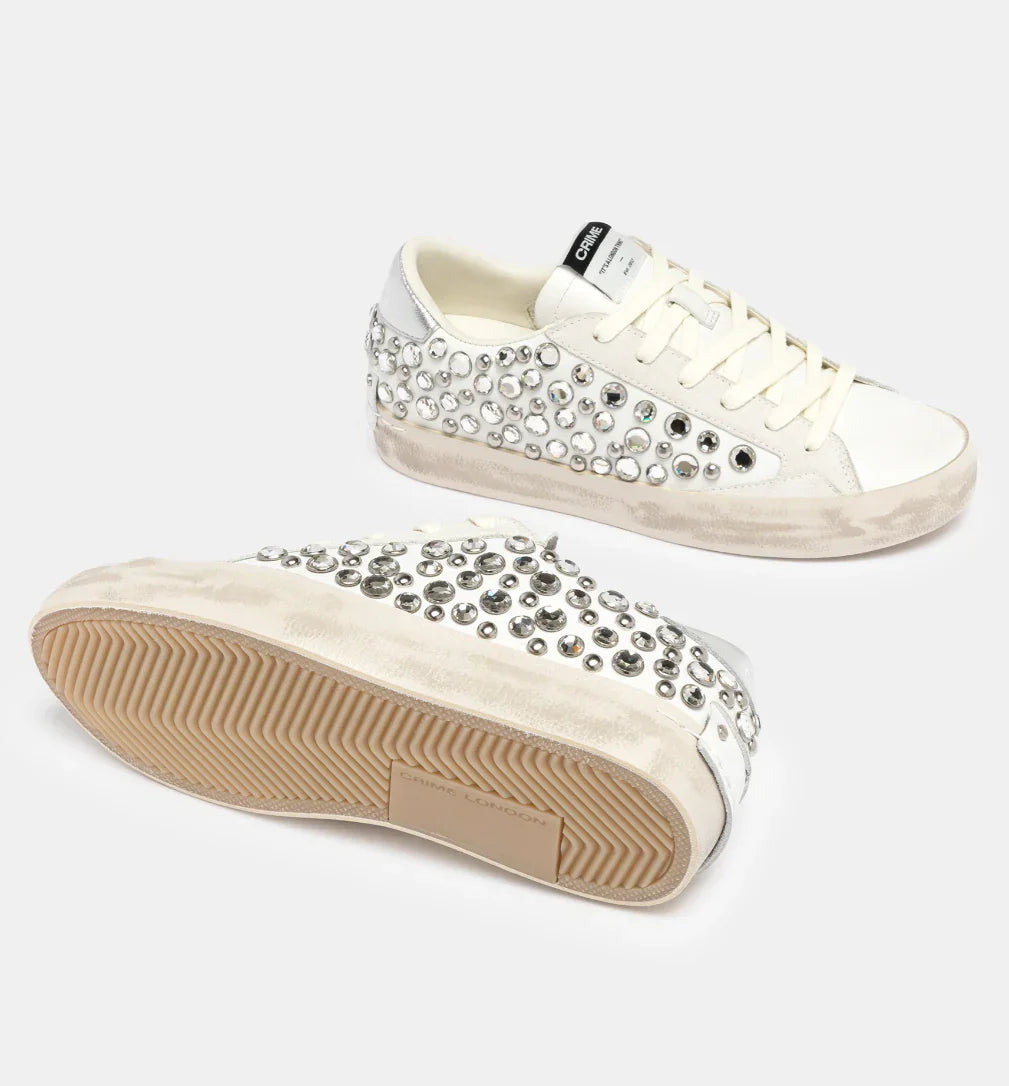 Sneakers donna bianche con borchie argento e dettagli in pelle, suola beige effetto vintage.