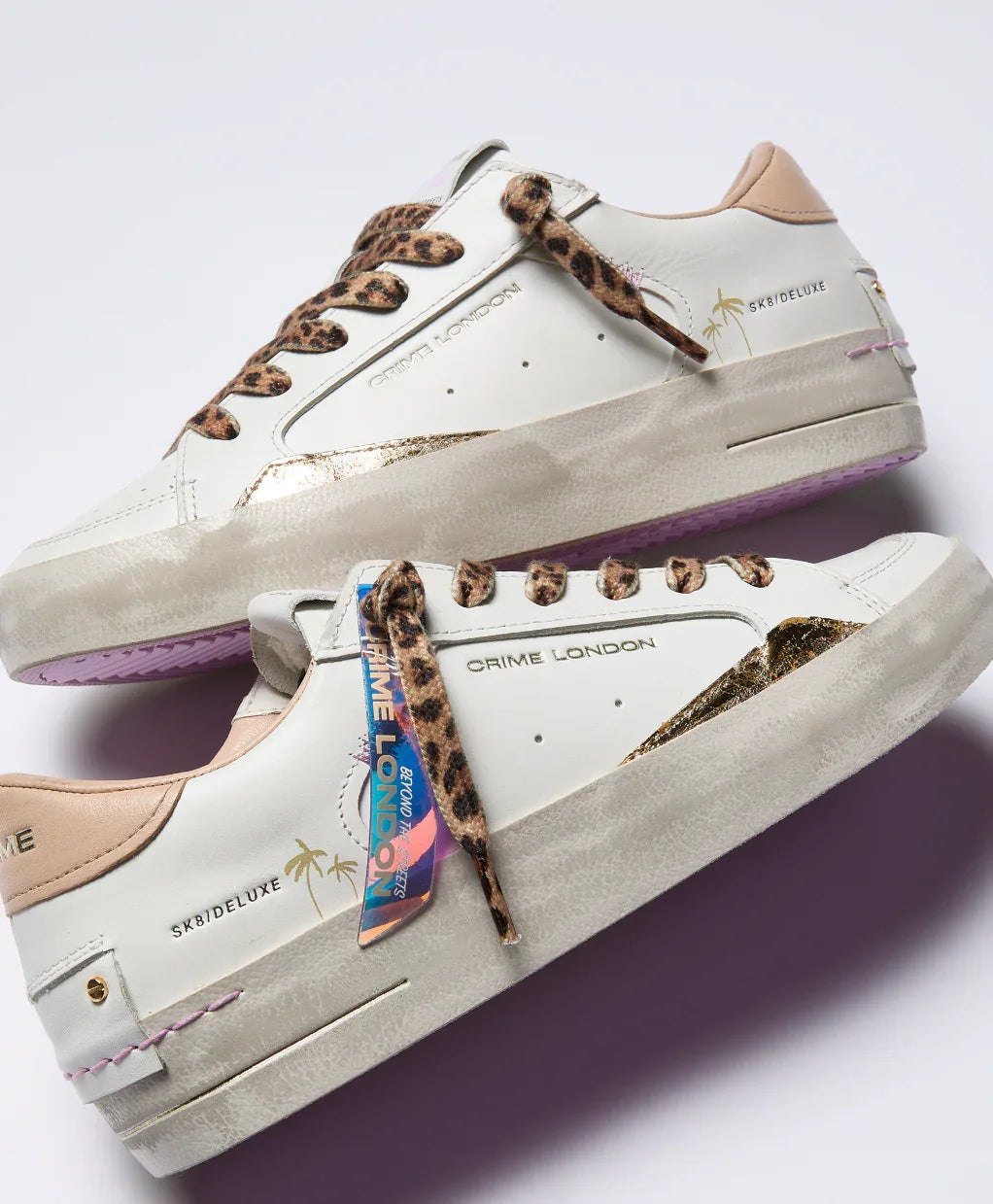 Sneakers donna bianche con dettagli leopardati, logo Crime London, accenti oro e suola beige.