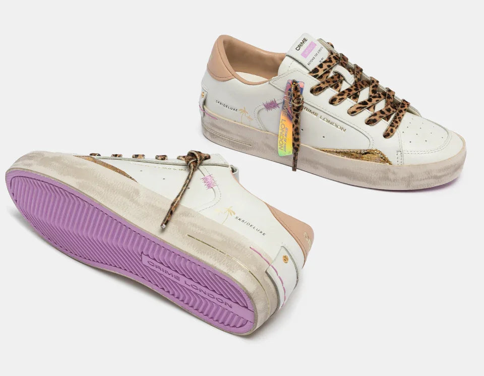 Sneakers donna bianche con suola lilla, lacci animalier, dettagli oro e inserti colorati.