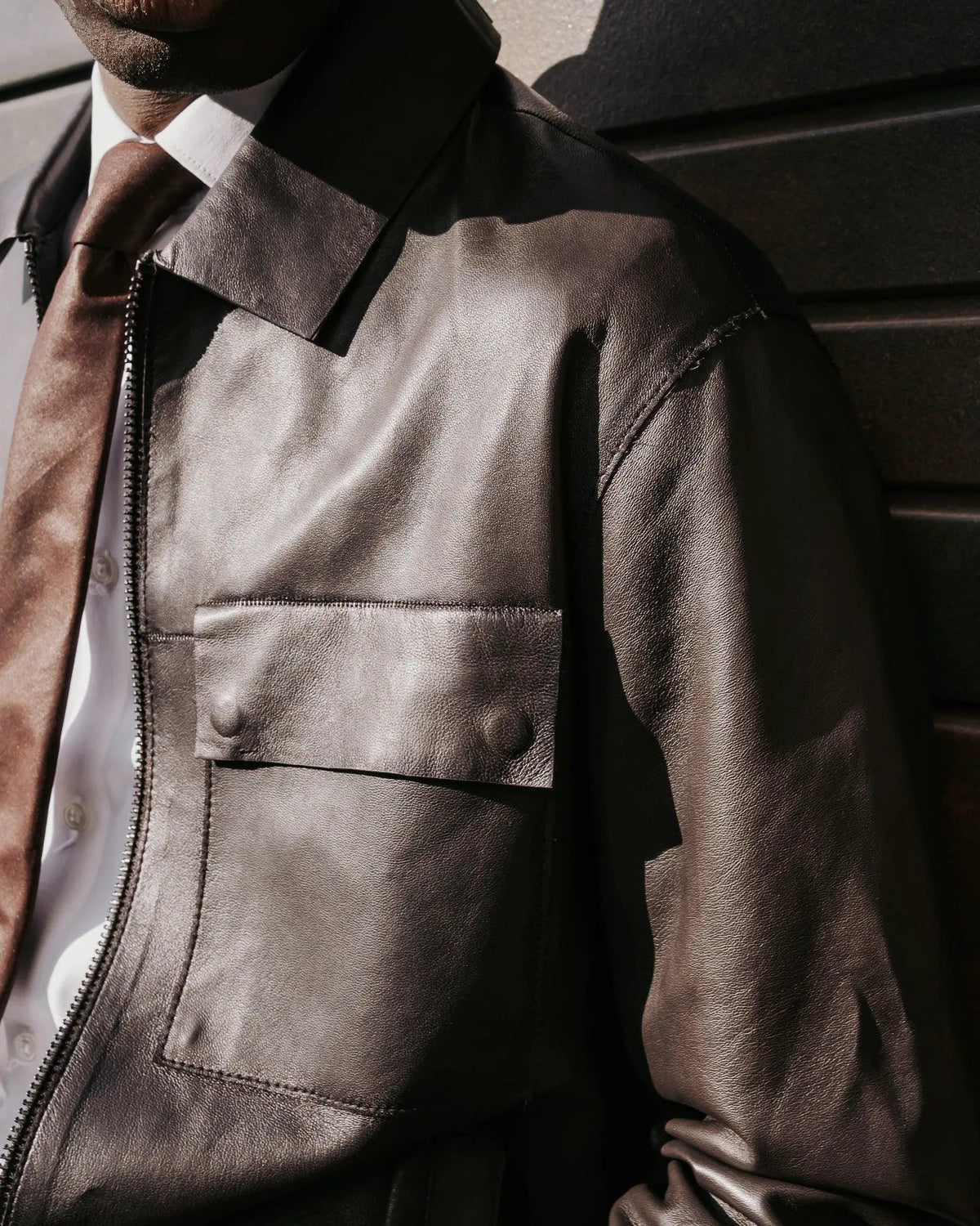 Giacca uomo in pelle marrone, dettagli tasca e zip, stile elegante, moda maschile