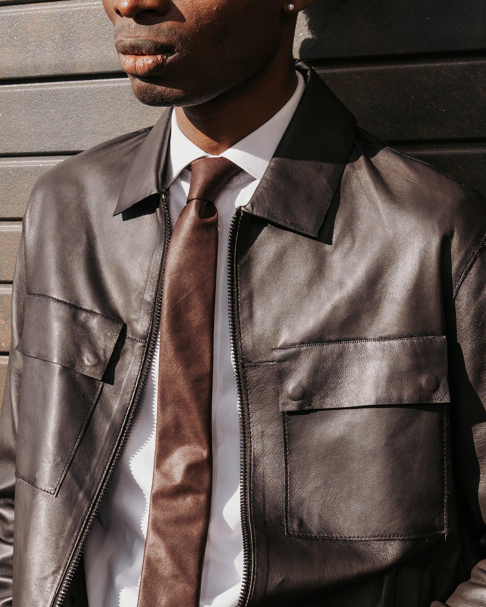 Giacca in pelle uomo nera, camicia bianca e cravatta marrone, moda elegante