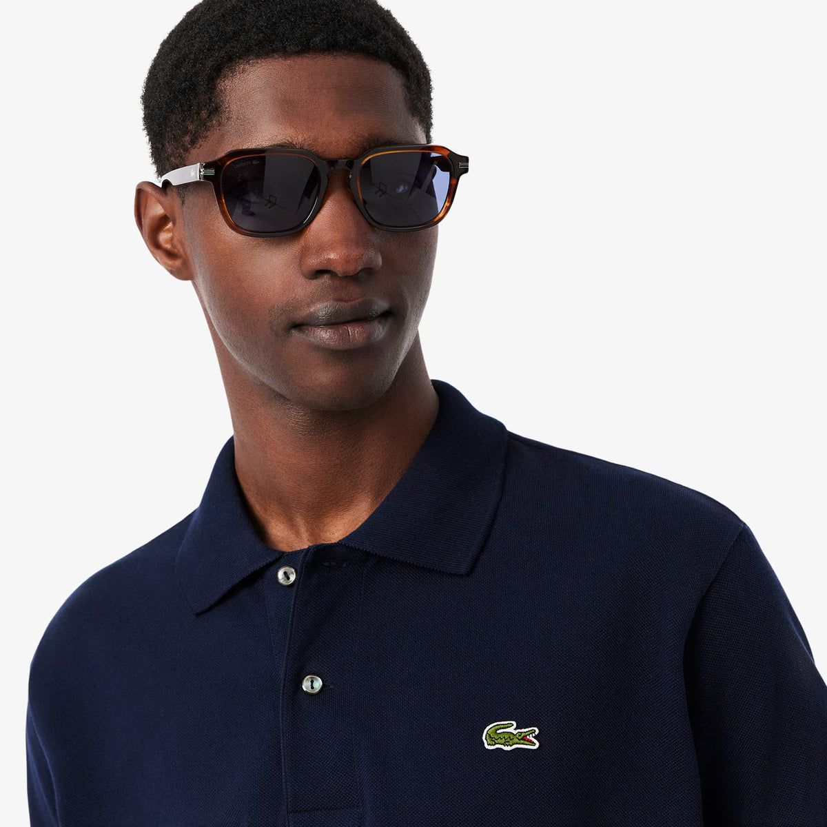 Polo LACOSTE L1212 166 con taglio classico, colore verde, tessuto morbido, dettagli a costine e logo crocodile sul petto.