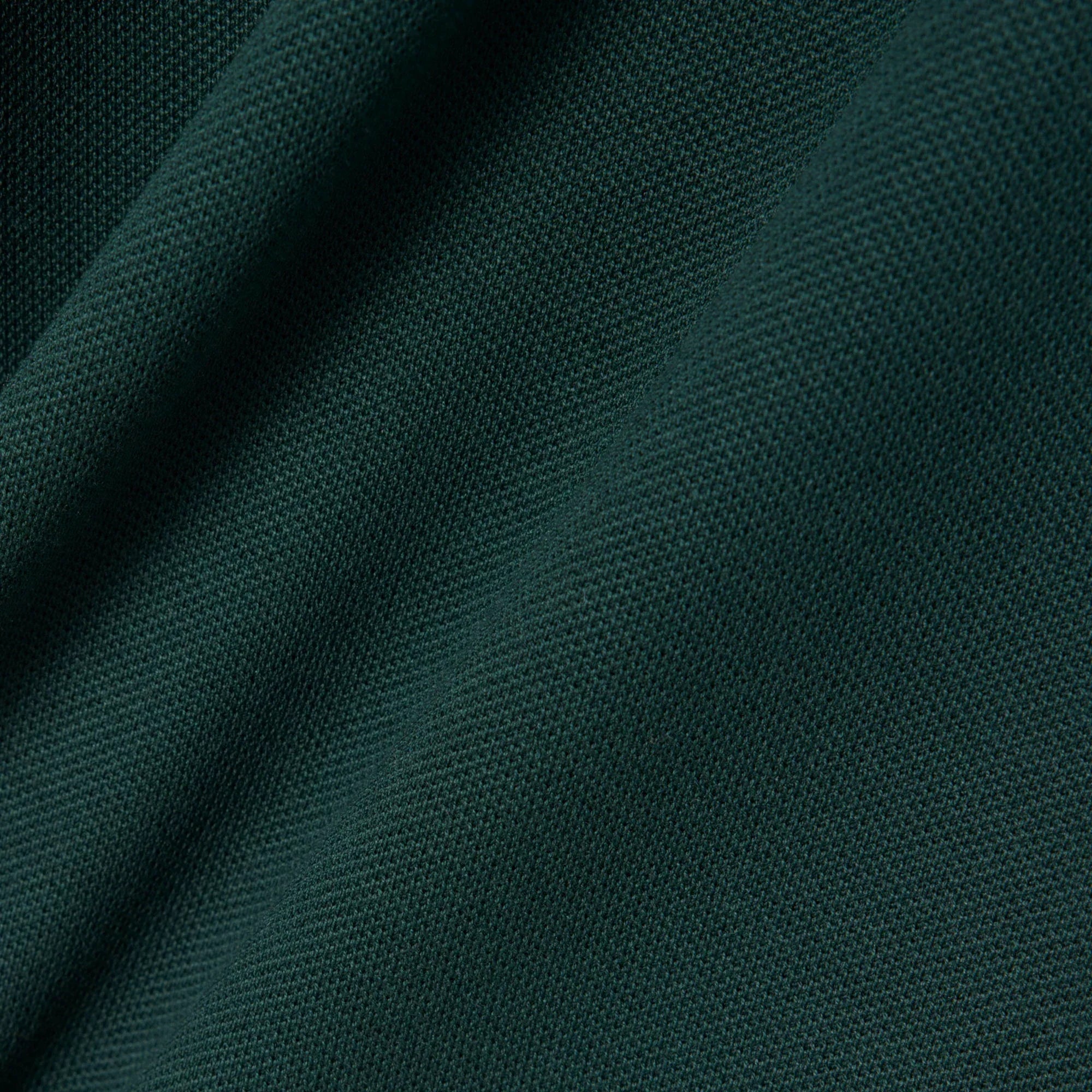 dettaglio tessuto piqué verde scuro, primo piano texture abbigliamento elegante uomo donna