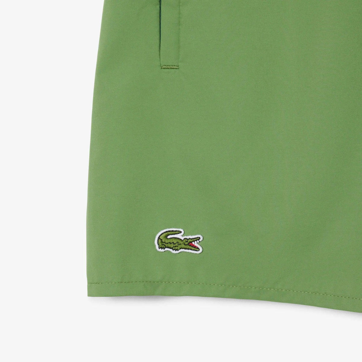 Dettaglio shorts verdi uomo con logo ricamato, tasca laterale, moda primavera estate.