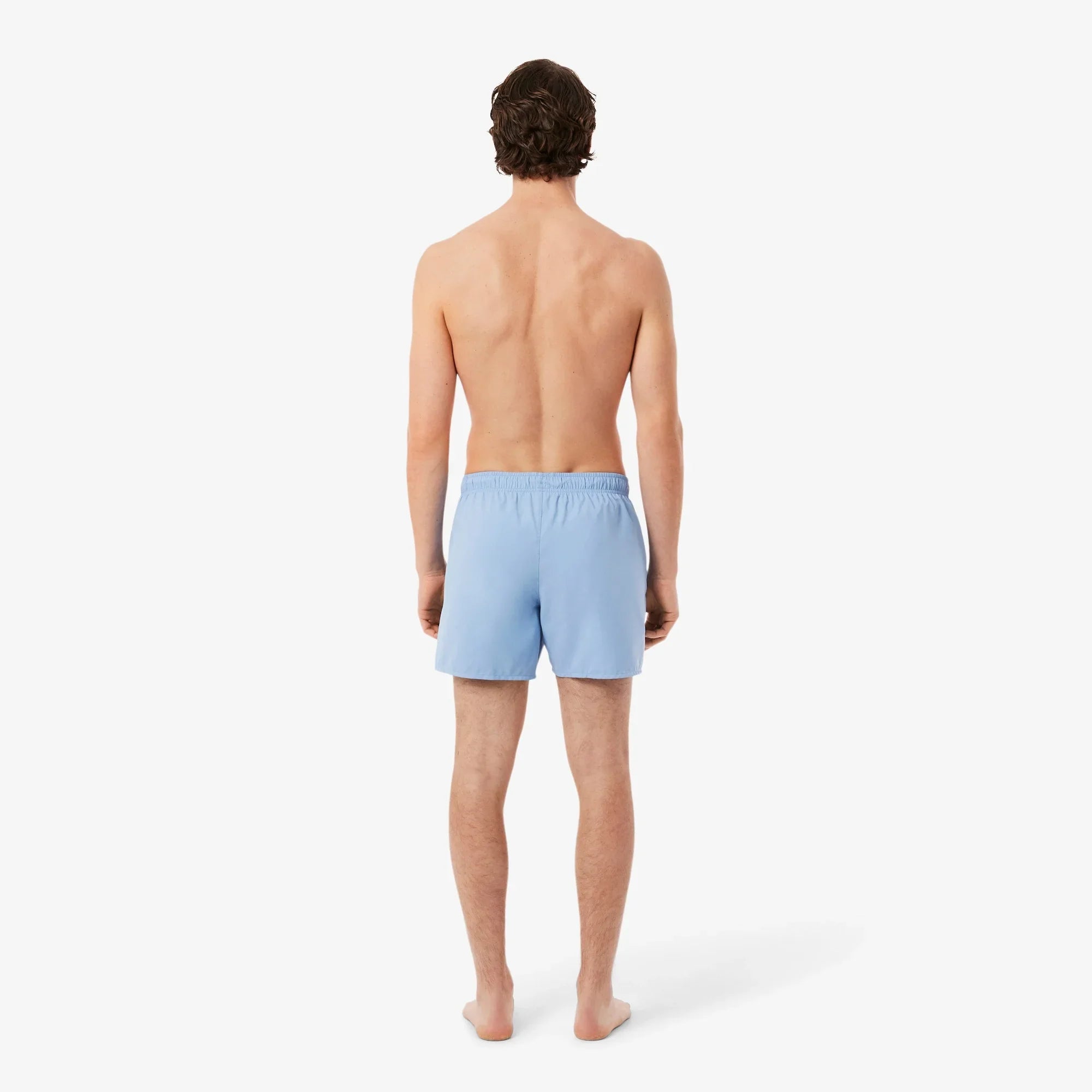 Uomo di schiena indossa pantaloncini corti azzurri da uomo su sfondo bianco