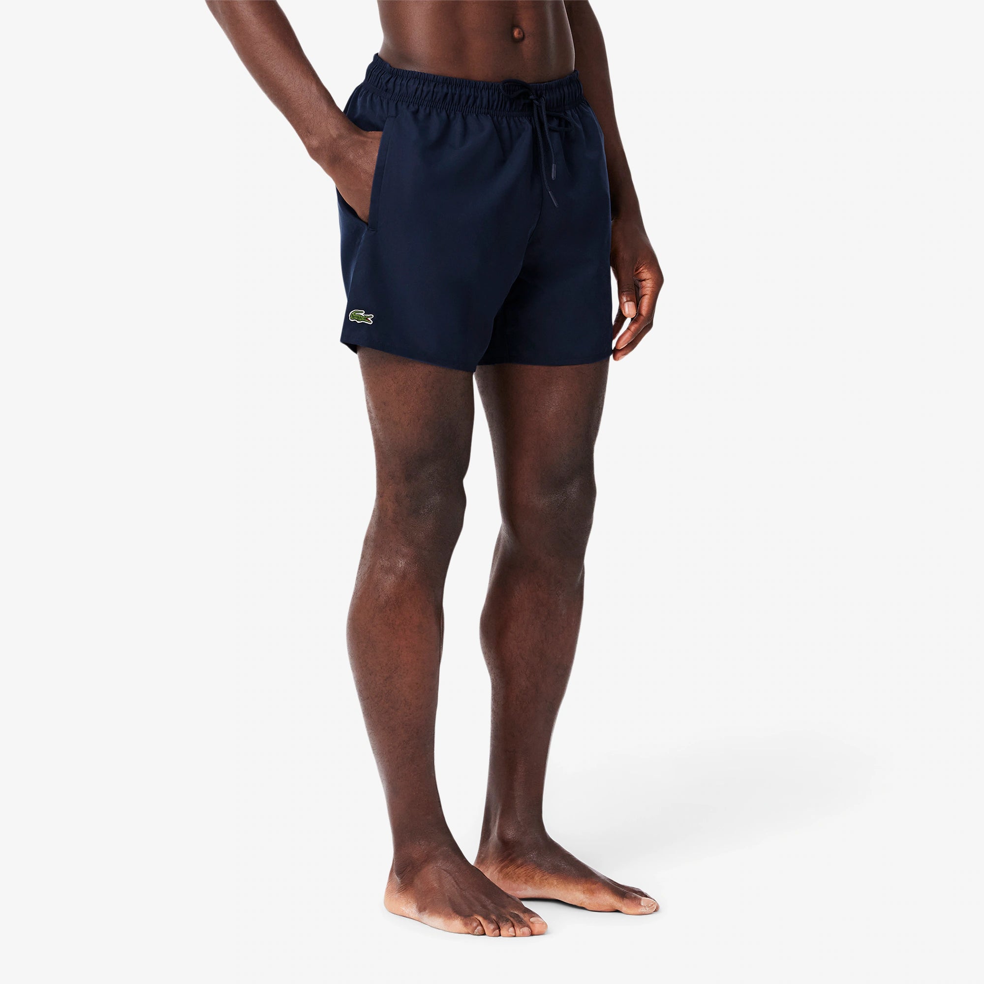 Modello indossa boxer mare uomo blu scuro con logo ricamato, vestibilità comoda, stile casual.