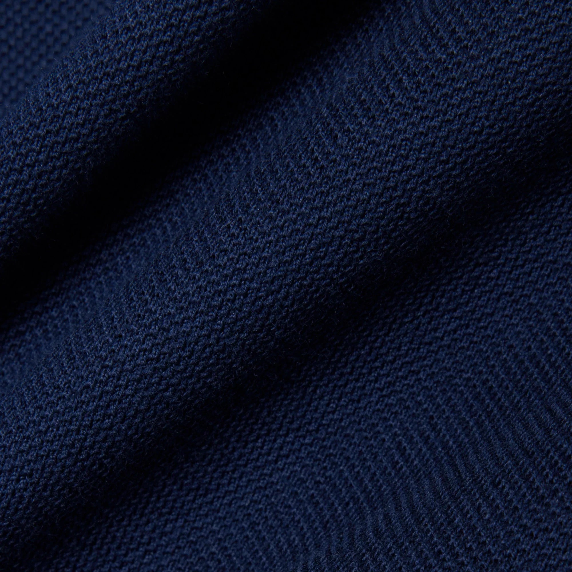 Dettaglio tessuto maglia blu navy, texture morbida, abbigliamento uomo donna elegante