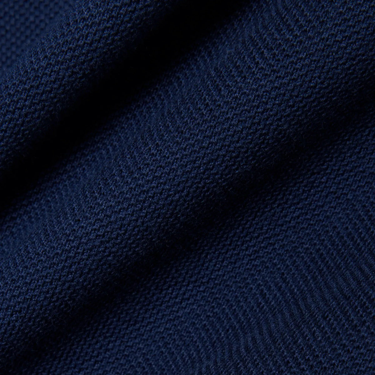 Dettaglio tessuto maglia blu navy, texture morbida, abbigliamento uomo donna elegante