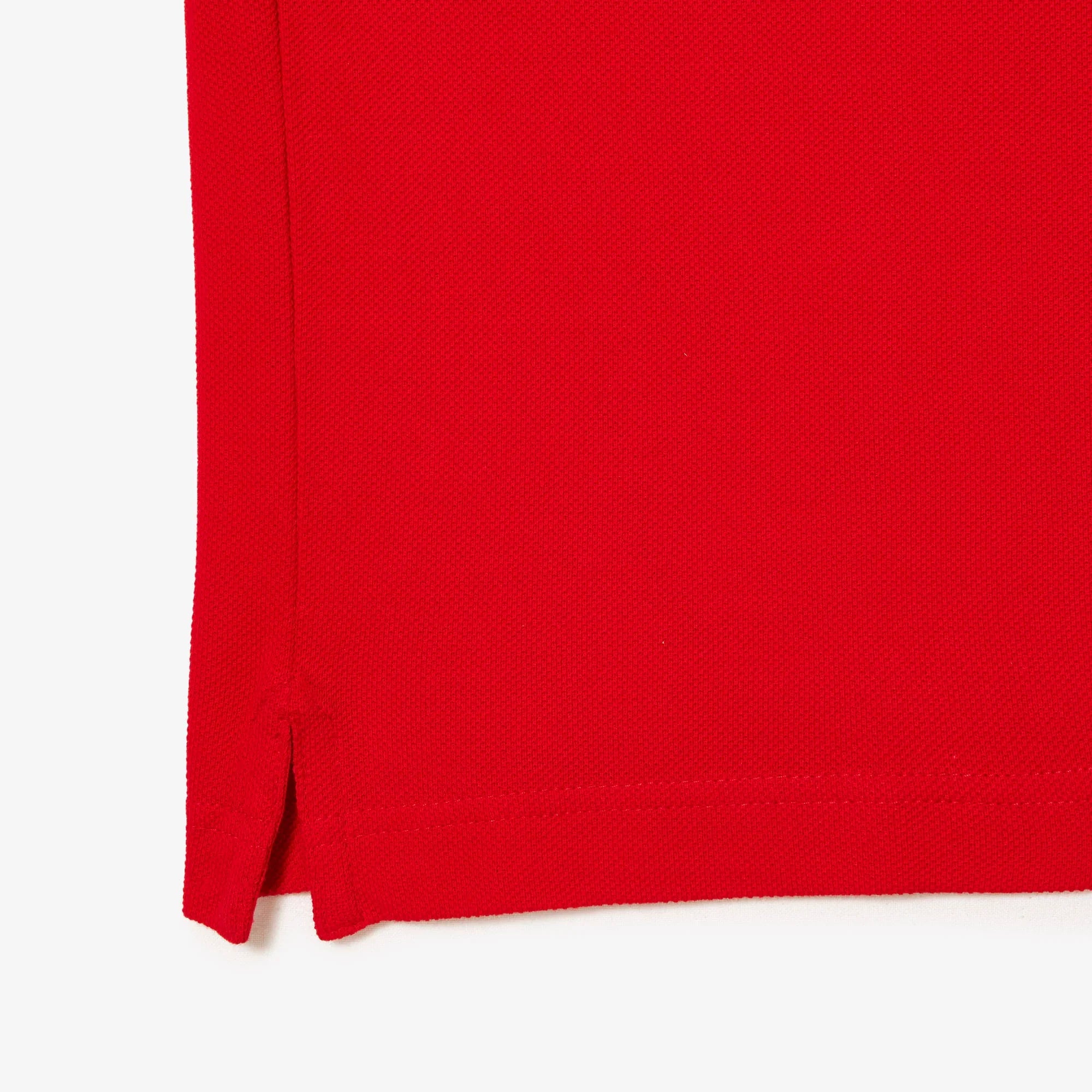 Dettaglio fondo polo rossa in cotone piqué, spacco laterale, abbigliamento uomo