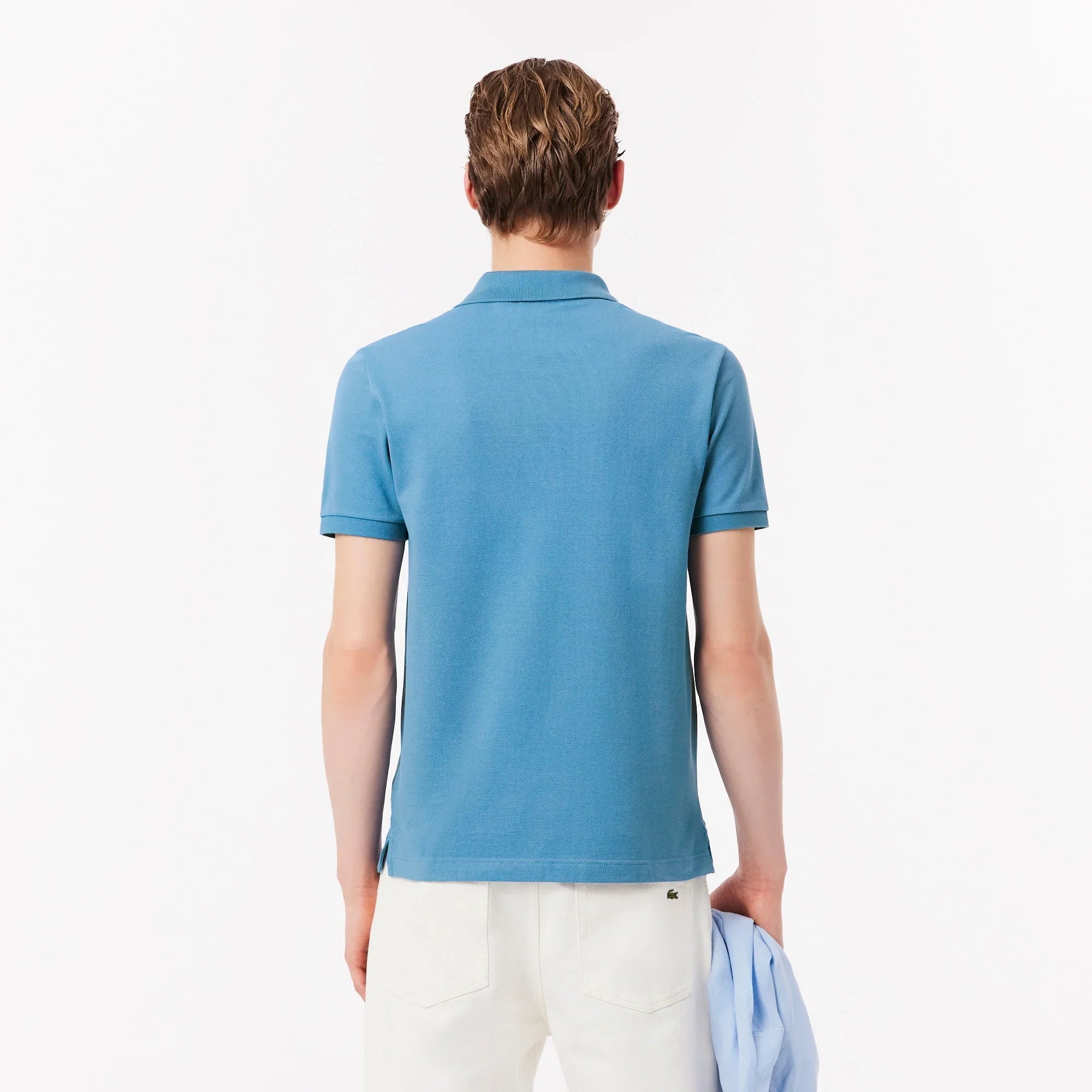 Uomo di spalle con polo azzurra e pantaloni bianchi, moda casual uomo.