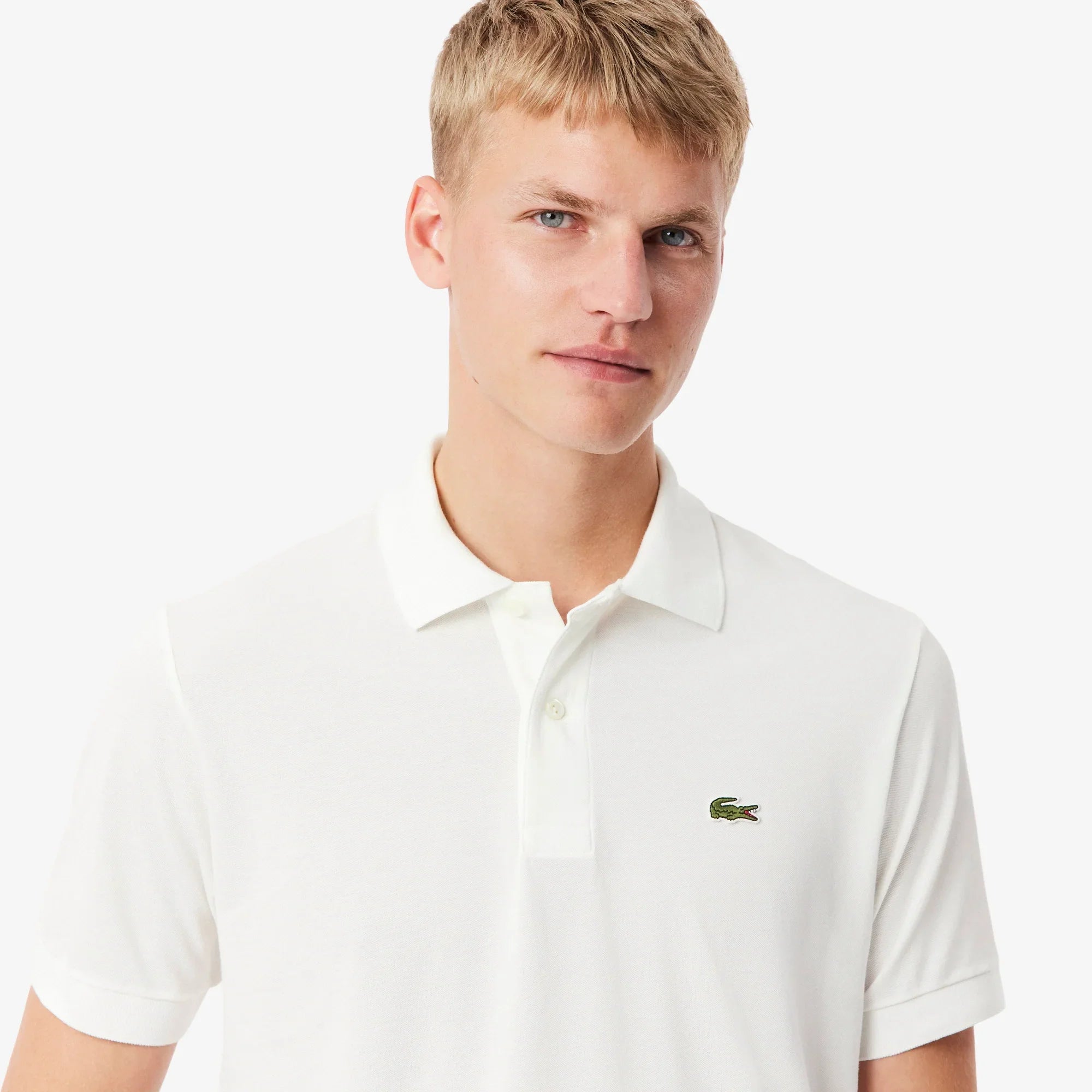 Uomo con polo bianca in cotone piqué, logo piccolo ricamato sul petto, moda uomo elegante