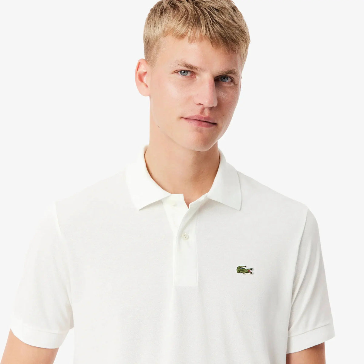 Uomo con polo bianca in cotone piqué, logo piccolo ricamato sul petto, moda uomo elegante
