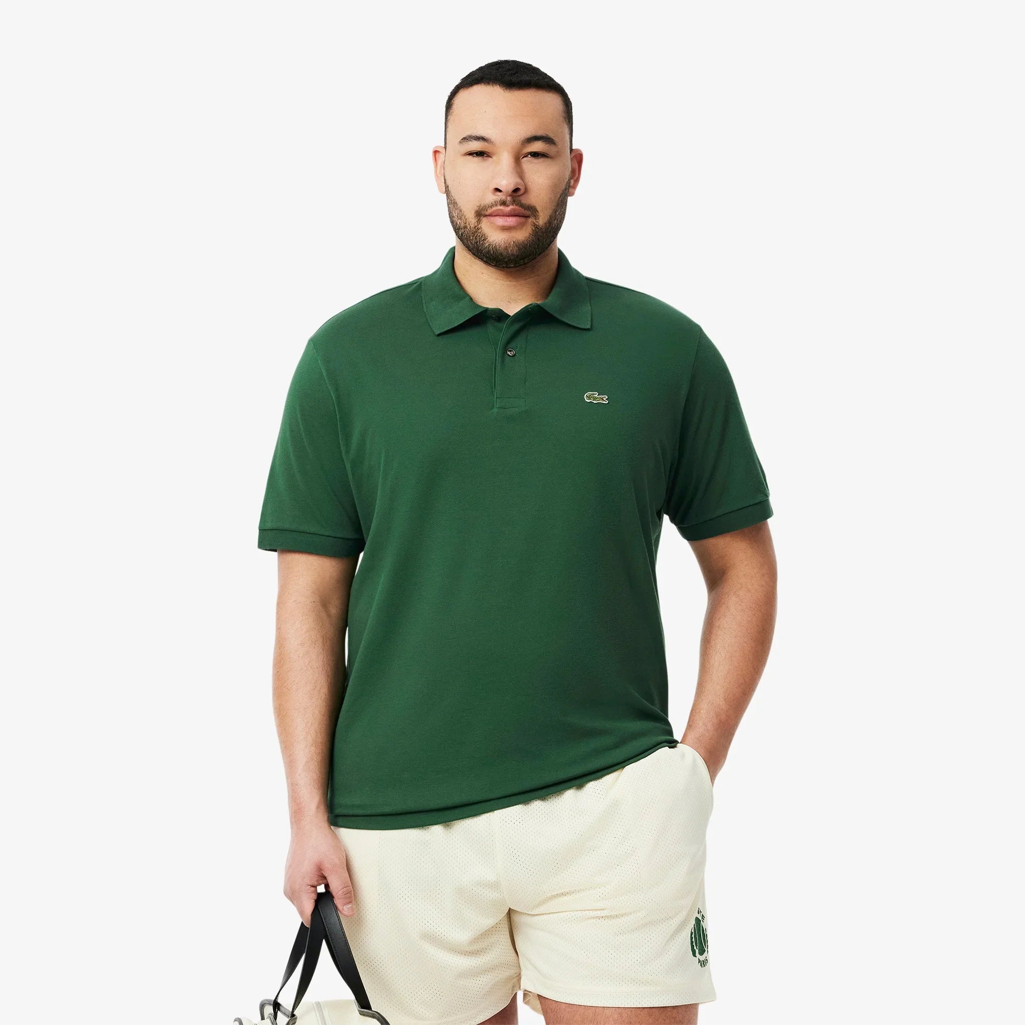 Uomo con polo verde e pantaloncini beige, abbigliamento casual uomo elegante.