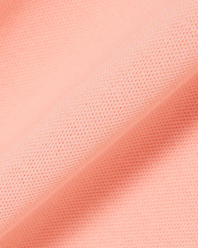 Dettaglio tessuto piqué rosa chiaro, texture a nido d'ape, abbigliamento moda