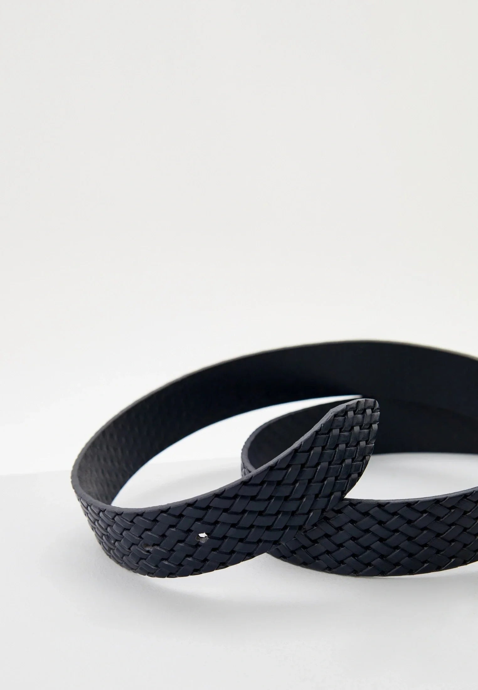 Cintura uomo intrecciata in pelle nera, accessorio moda elegante su sfondo chiaro.