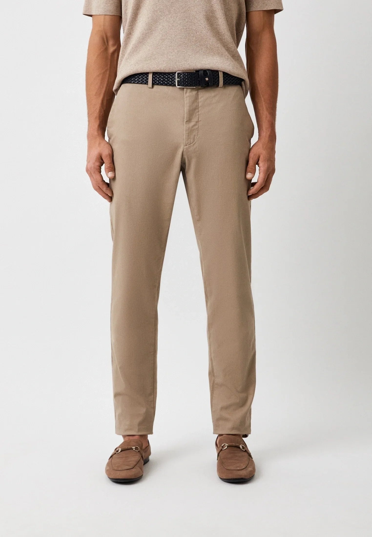 Pantaloni chino uomo beige, cintura intrecciata nera e mocassini eleganti, look casual.