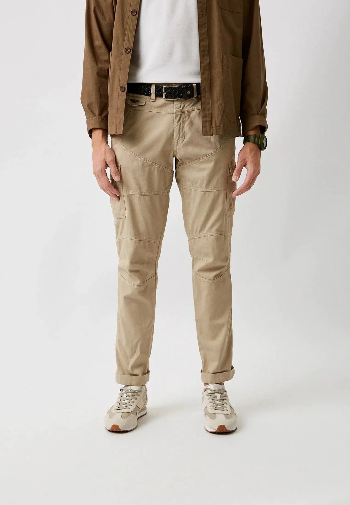 Pantaloni cargo uomo beige stile casual, camicia marrone, sneakers chiare, moda uomo