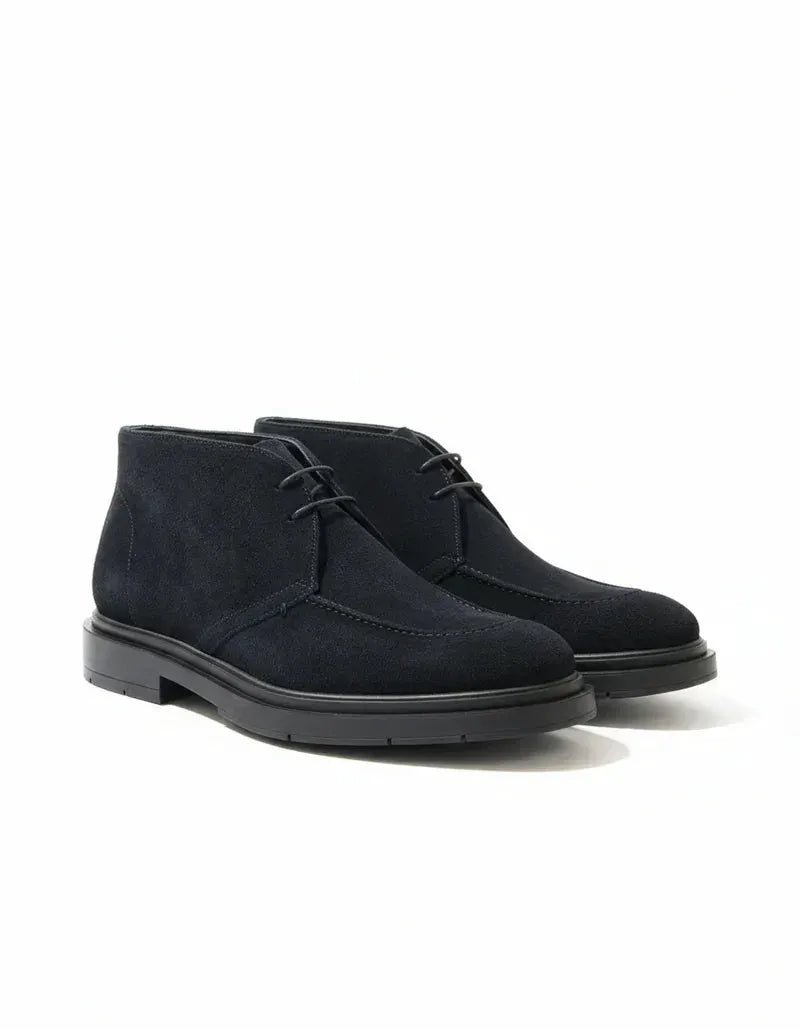 Stivaletti chukka blu da uomo in camoscio con suola nera, eleganti e moderni.