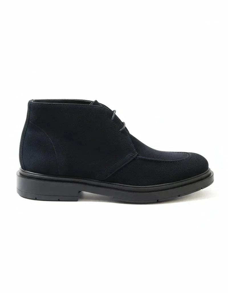 Stivaletto Chukka blu da uomo in pelle scamosciata su fondo bianco, elegante e moderno