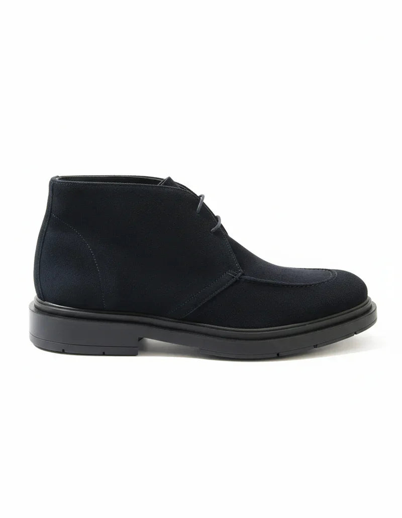 Stivaletto Chukka blu da uomo in pelle scamosciata su fondo bianco, elegante e moderno